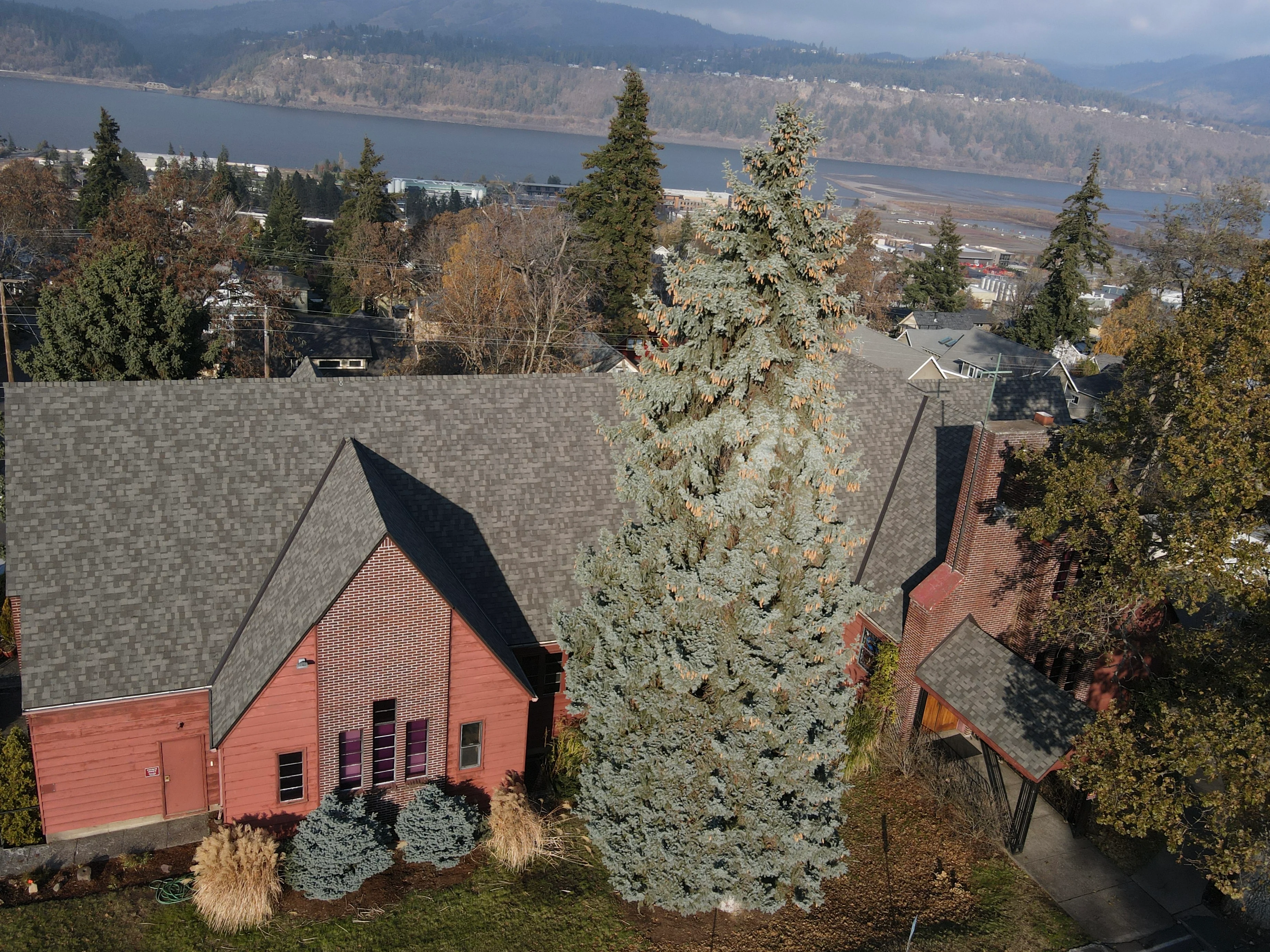 Gray architectural shingle roof on brick home with multiple peaks and valleys